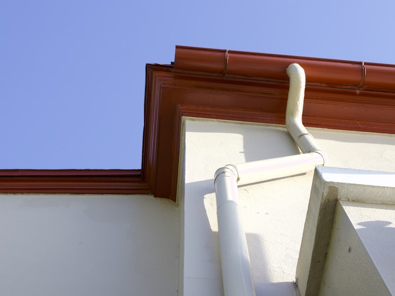 Gutter and downspout system on residential building against blue sky