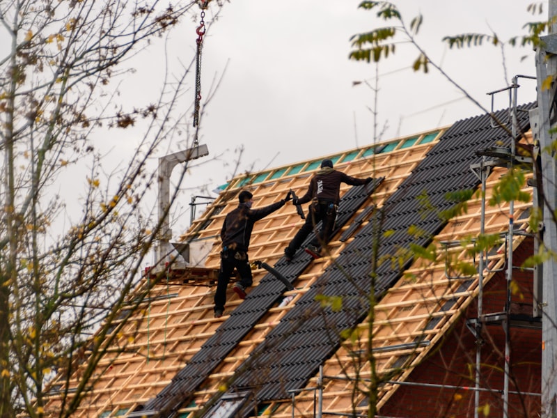Construction crew installing new roofing materials on residential home