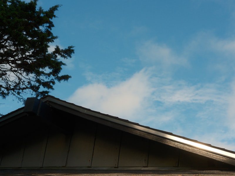 Residential roofline with gutters and clear blue sky