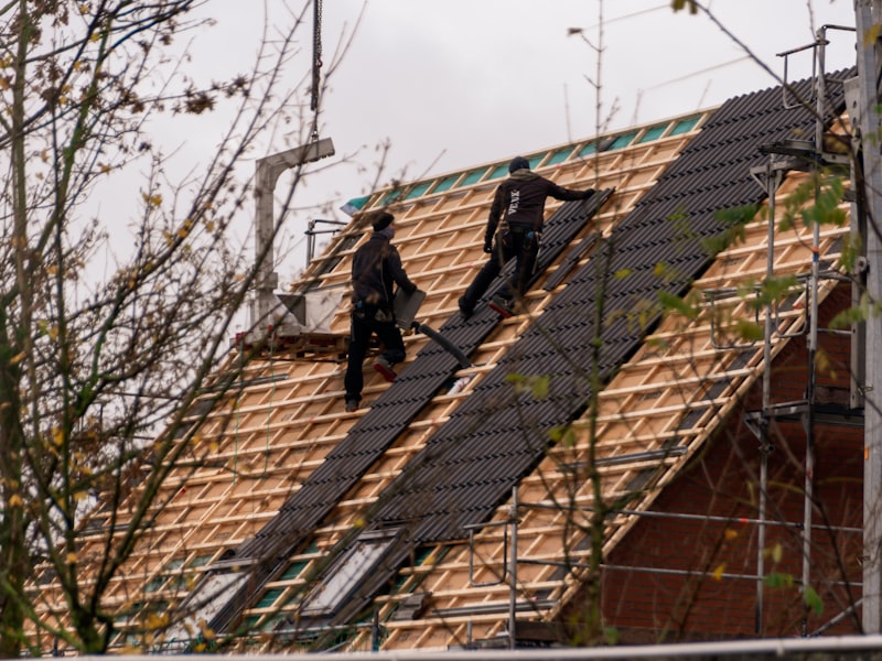 Professional roofing crew installing shingles on residential roof